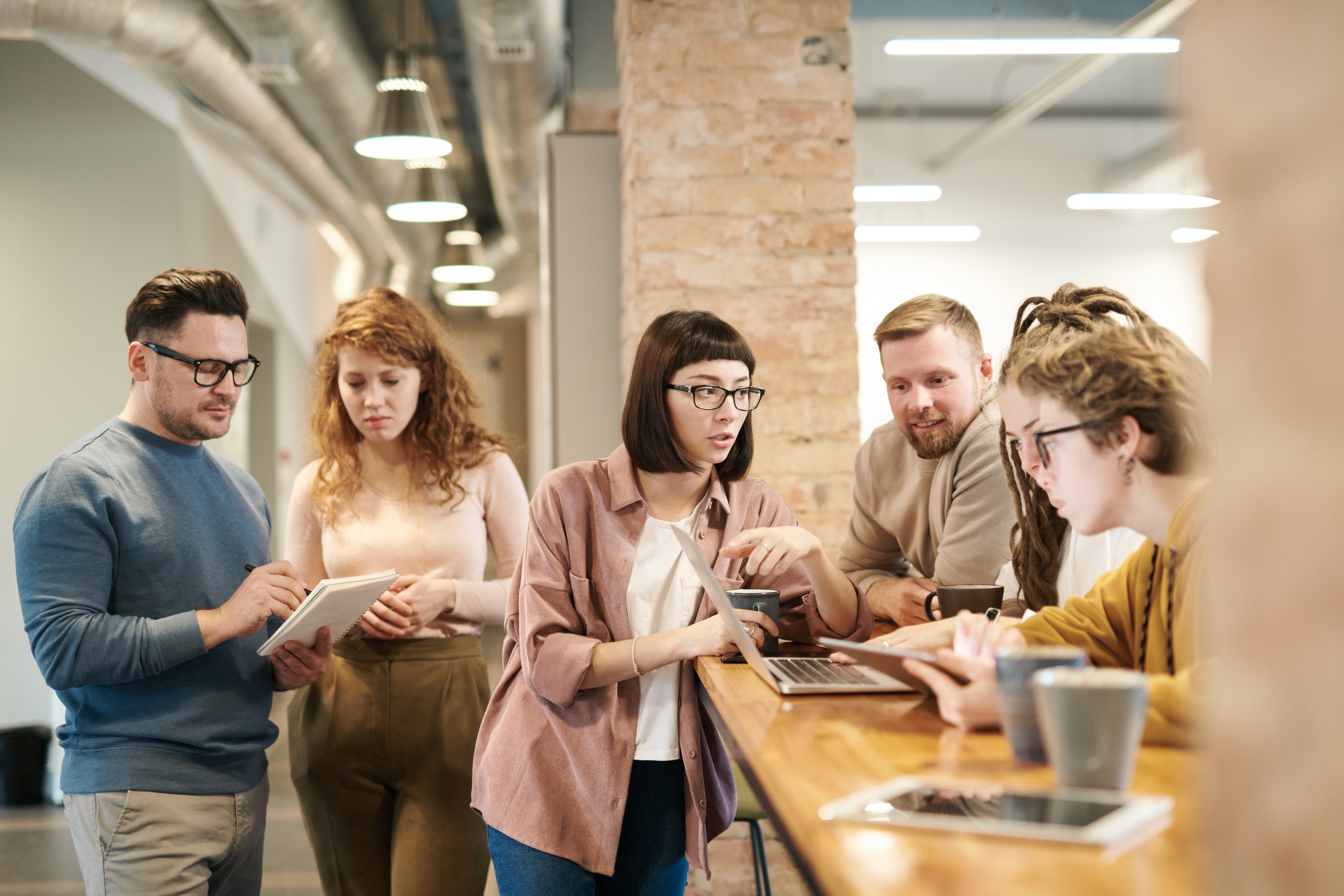 grupo de personas jovenes trabajando en cerca de una barra en un co-working